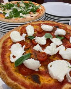 Duas pizzas com queijo e tomates numa mesa em AMBRA HOTEL - The only central lakeside hotel in Iseo em Iseo