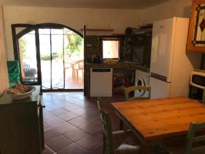 ラ・マッダレーナにあるvilla palmaのキッチン(木製テーブル付)、ドアが開くキッチン