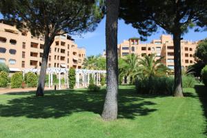 un grupo de árboles en un parque con edificios en APTO. DE 1 DORMITORIO EN PRIMERA LINEA DE PLAYA. ISLA CANELA, en Huelva