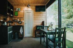 cocina y comedor con mesa y ventana en Mirror house, en Tīnūži