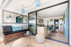 a living room with a couch and a kitchen at Blue Luxury House Port Nature Naturiste in Cap d'Agde