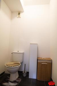 a bathroom with a toilet and a trash can at MADININA DAY in Saint-Médard-en-Jalles