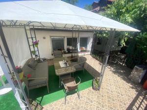 un patio esterno con ombrellone e sedie bianchi di Studio Apartments Siesta a Sarajevo