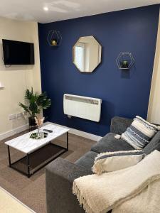 a living room with a couch and a blue wall at Elite 60 Stays in Newcastle upon Tyne