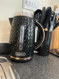 a black coffee cup sitting on top of a counter at Elite 60 Stays in Newcastle upon Tyne