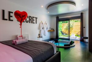 a bedroom with a bed with a heart balloon on the wall at Le Secret - Nuit romantique avec Jacuzzi privatif - Champagne offert - Climatisation in Nantes
