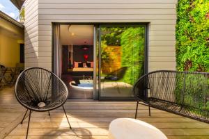 two chairs sitting on a porch with a patio at Le Secret - Nuit romantique avec Jacuzzi privatif - Champagne offert - Climatisation in Nantes