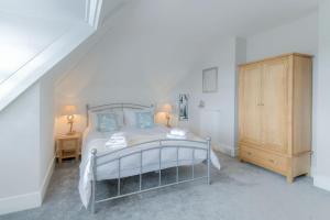 ムンデスリーにあるHilltop Mundesleyのベッドルーム1室(ベッド1台付)、木製キャビネットが備わります。
