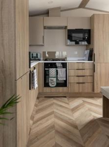 a kitchen with wooden cabinets and a counter top at The Beach Hut, Burghead in Burghead