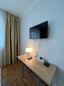 a room with a table with a television on a wall at Khongor Guest house & Tours in Ulaanbaatar