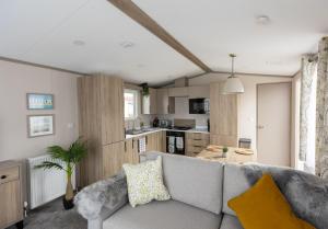 a living room with a couch and a kitchen at The Beach Hut, Burghead in Burghead