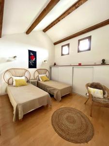 een kamer met 2 bedden, een stoel en een tapijt bij "Les Oiseaux" avec terrasse, parking, duplex in Le Chambon-sur-Lignon