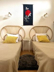 twee bedden naast elkaar in een kamer bij "Les Oiseaux" avec terrasse, parking, duplex in Le Chambon-sur-Lignon