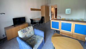 uma sala de estar com um sofá e uma cadeira e uma televisão em Ascona: Sabrina Apt. 237 em Ascona