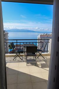 einen Balkon mit einem Tisch und Stühlen sowie Meerblick in der Unterkunft Albania Dream Holidays Accommodation in Sarandë