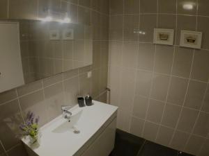a bathroom with a white sink and a mirror at Casa Vista Mar in Luz