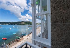 a window view of a beach and the water at Apartamentos Bestarruza in Mugardos
