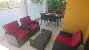 an outdoor patio with chairs and tables and a table at Sunset apartmani in Ždrelac