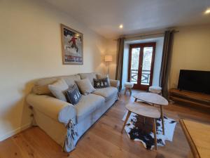 salon z kanapą i telewizorem w obiekcie Appartement Marquise de 110m2 avec vue et sauna à 10 min des pistes w mieście Sainte-Foy-Tarentaise