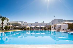 a large swimming pool with chairs and umbrellas at TMK Hotel Flora Park - Adults Only in Hammamet