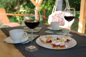 stół z dwoma kieliszkami wina i talerzem jedzenia w obiekcie Domki w Nowicy w mieście Nowica