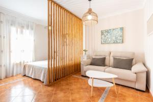 salon z kanapą i łóżkiem w obiekcie Casa Angelita Caminito del Rey, Dúplex con terraza en el centro de Andalucía w mieście Valle de Abdalagís