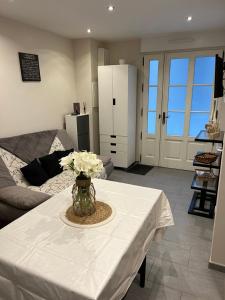 una sala de estar con una mesa con un jarrón de flores. en Dieppe duplex cosy en hyper centre, en Dieppe