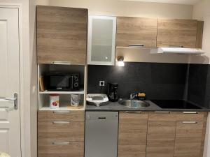 una cocina con armarios de madera y fregadero en Dieppe duplex cosy en hyper centre, en Dieppe