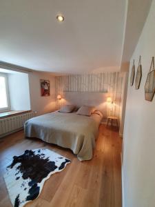 a bedroom with a large bed and a wooden floor at Appartement Gentiane de 85m2 avec sauna à 10 min des pistes in Sainte-Foy-Tarentaise