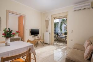 ein Wohnzimmer mit einem Sofa und einem Tisch in der Unterkunft Luxury Coastal Retreat, Mountain View Balcony with Palm Trees & Parking in Chania