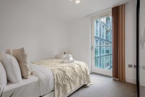 a white bedroom with a bed and a window at Three Bedroom Serviced apartment in Old Street in London