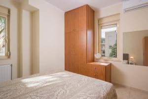 ハニア・タウンにあるLuxury Coastal Retreat, Mountain View Balcony with Palm Trees & Parkingのベッドと木製のキャビネットのある寝室