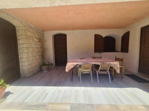 eine Terrasse mit einem Tisch und Stühlen in einem Zimmer in der Unterkunft Les Buisses en Provence in Piolenc