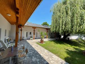 un patio con tavolo, sedie e un albero di Liget Üdülőpark Fonyód a Fonyód