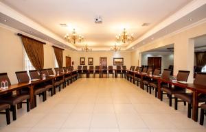 a large conference room with long tables and chairs at Afrique Boutique Hotel O.R. Tambo in Boksburg