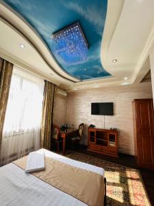 a bedroom with a bed and a tv on the ceiling at Akzhol Hotel Almaty in Almaty