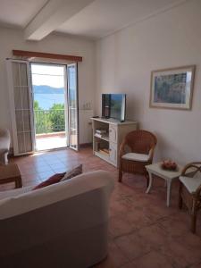 a living room with a couch and a television at Melissani House in Karavomylos