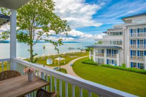 uma varanda de um condomínio com vista para a água em BalaLake Resort em Szántód