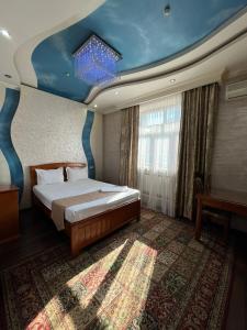 a bedroom with a bed and a blue ceiling at Akzhol Hotel Almaty in Almaty