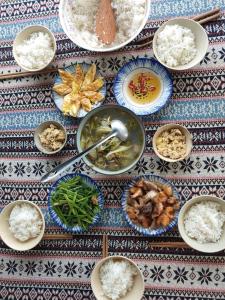 a table topped with bowls of food with rice and vegetables at nhà Ba cơm Má in Phương Phi