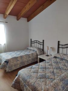 ein Schlafzimmer mit 2 Betten und einem Tisch mit einer Lampe in der Unterkunft Casa Rural Casas Nuevas in Nerpio
