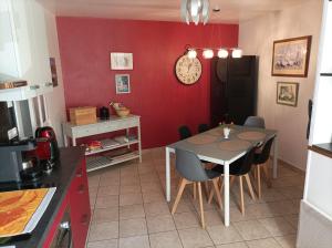 - une cuisine avec une table à manger et un mur rouge dans l'établissement Colourful well equipped 2-Bed House in Le Vigeant, à Le Vigeant