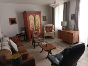 - un salon avec un canapé et une chaise dans l'établissement Colourful well equipped 2-Bed House in Le Vigeant, à Le Vigeant