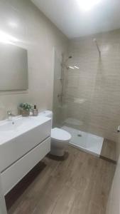 uma casa de banho com um lavatório, um WC e um chuveiro em Casita Barrena em Bueu