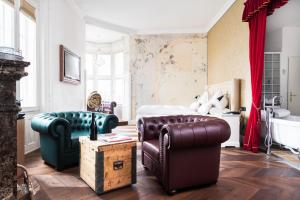 a bedroom with a bed and two chairs and a couch at Grand Hôtel Wiesler - Centre of Graz in Graz +36 photos