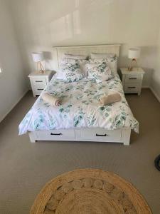 a bedroom with a bed with two night stands and two lamps at Furnished Home near Newcastle and Warners Bay in Mount Hutton