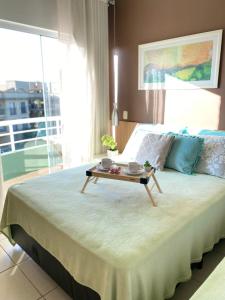 a bedroom with a bed with a table on it at Flat no Aldeia das Águas Park Resort in Barra do Piraí +46 photos