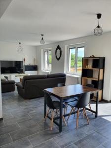 ein Wohnzimmer mit einem Tisch und einem Sofa in der Unterkunft Maison calme proche zoo beauval et chateaux de la loire in Contres
