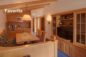 cocina y comedor con mesa y TV en Swissflair Apartments, en Zermatt