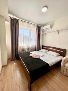 a bedroom with a large bed with a window at Apartmant in Kyiv for you in Kyiv